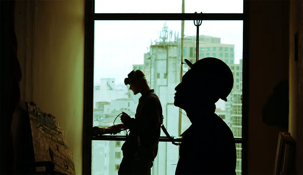 Silhouette of two construction workers doing daily inspection.