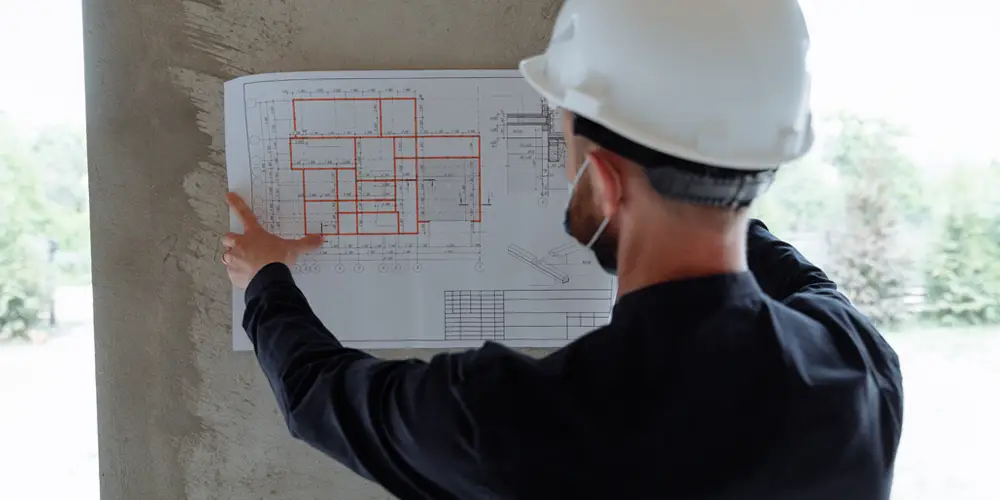 Photo of an Architect looking at a plan on site.